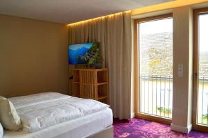 a bedroom with a bed and a large window at Zimmer am Platz in Purgstall