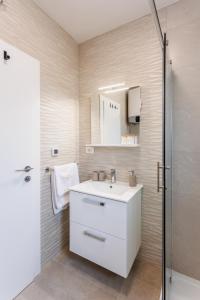 W łazience znajduje się biała umywalka i prysznic. w obiekcie Apartmani Tanita w mieście Kaštela