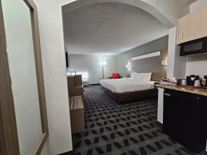 a hotel room with a bed and a kitchen at Quality Inn & Suites Irving DFW Airport South in Irving
