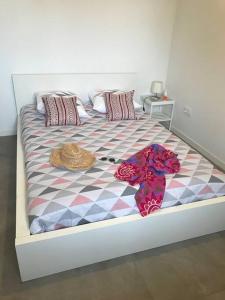 een bed met hoeden en kussens erop bij T3 contemporain, plein centre, terrasse et parking in Bayonne