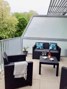 - une terrasse avec deux canapés et une table avec une boisson dans l'établissement T3 contemporain, plein centre, terrasse et parking, à Bayonne