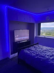 a bedroom with a bed and a flat screen tv at Sapphire Suites Stunning 2-Bed House in Bradford in Bradford
