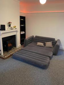 un sofá en una sala de estar con chimenea en Sapphire Suites Stunning 2-Bed House in Bradford en Bradford