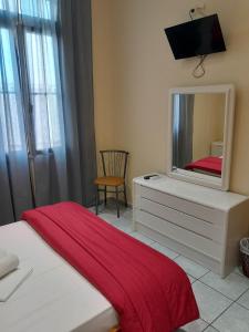 a bedroom with a bed and a mirror on a dresser at Ikaros in Piraeus