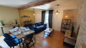 a living room with a table and a blue couch at appartement du croissant in Bayeux
