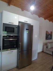uma cozinha com um frigorífico de aço inoxidável e um micro-ondas em Athanasias House Pyrgi em Áyios Ilías