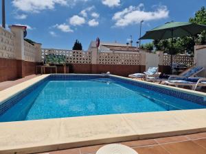 a swimming pool with chairs and an umbrella at Riumar "Camins", 380m to beach, private pool, On-Site-Service, dog beach in Riumar