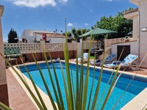a pool with a palm tree in front of a house at Riumar "Camins", 380m to beach, private pool, On-Site-Service, dog beach in Riumar