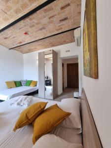 1 dormitorio con 1 cama grande con almohadas amarillas en CASALE DEI PRIORI en Rocca Massima