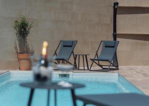 - deux chaises et une table à côté de la piscine dans l'établissement Aria di Mare Apartments, à Tivat