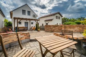 a patio with two wooden benches and a house at Vinoza - ubytování a vinný sklep Velké Bílovice Pod Vinicí in Velké Bílovice