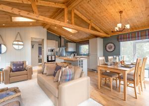 a living room with a couch and a dining room at Thirlestane Woodland Lodges in Lauder
