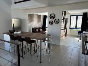 een keuken en een woonkamer met een houten tafel en stoelen bij L'atelier du peintre in Duinkerke