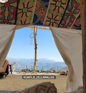 ビクーニャにあるCampo de Cielo Mamalluca Valle de Elquiのテントの下から砂漠の景色を望めます。