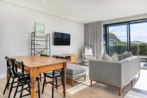 a living room with a table and chairs and a couch at Stonehurst Views - 1 Bed Flatlet in Cape Town