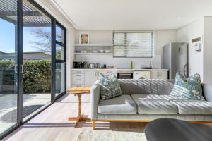 a living room with a couch and a kitchen at Stonehurst Views - 1 Bed Flatlet in Cape Town
