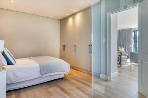 a bedroom with a bed and a sliding glass door at Stonehurst Views - 1 Bed Flatlet in Cape Town
