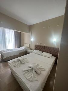 Dos camas en una habitación de hotel con toallas. en Koz Eren Otel Çeşme, en Cesme