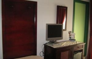 Hotel Ristorante La Scogliera في أمانتيا: وجود شاشة كمبيوتر جالسة فوق مكتب في غرفة