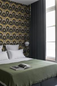 1 dormitorio con 1 cama con manta verde y pared en MiHotel Sala en Lyon