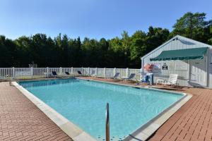 a man standing in front of a swimming pool at Acadia Inn in Bar Harbor