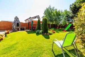 un cortile con una sedia verde e un parco giochi di Pokoje gościnne Panda a Karwia