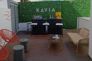 a patio with a bar with a green wall at Kavia Hotel do Largo in Cascais