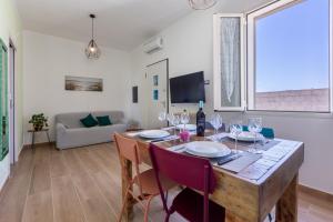 a dining room with a table with wine glasses at The aurora's home in Quartu SantʼElena