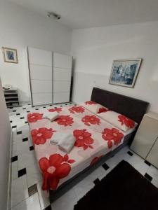 a bedroom with a bed with red flowers on it at Studio Sakic in Split