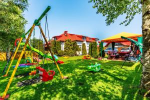 un patio con parque infantil y una casa en Pokoje gościnne Panda en Karwia