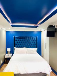 a blue bedroom with a bed with a blue ceiling at Mpisana boutique guesthouse in Tweefontein