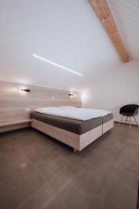 a bedroom with a large bed and a chair at Apartma & RAfting in Kobarid