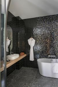 a bathroom with two sinks and a bath tub at MiHotel Sala in Lyon