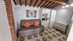 a living room with a couch with two orange pillows at La Corte in Marciana Marina