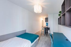 a small bedroom with a bed and a table at Cute Studio close to Paris - 1P - 422 in Ivry-sur-Seine