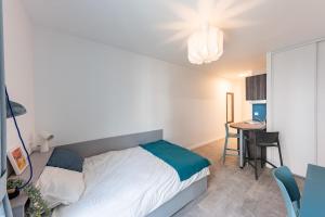 Dormitorio pequeño con cama y mesa en Cute Studio close to Paris - 1P - 422 en Ivry-sur-Seine