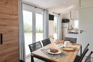 une cuisine et une salle à manger avec une table et des chaises en bois dans l'établissement Camping Park Er Lann, à Saint-Pierre-Quiberon 30 autres photos