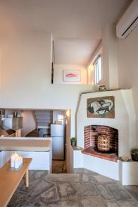 a living room with a brick fireplace in a kitchen at Alterra Vita Captain's Cabin in Neos Marmaras