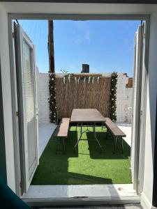 een patio met een tafel en een picknicktafel door een raam bij Quirky House Blackpool in Blackpool