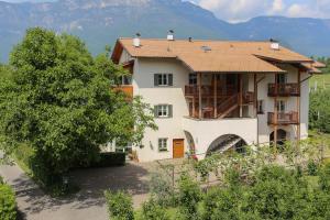 una casa con un árbol delante de ella en Waldthalerhof, en Monticolo