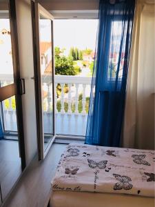 a bedroom with a bed and a view of a balcony at Guest House Jadro in Rovinj