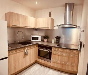 eine Küche mit Holzschränken und einer Mikrowelle in der Unterkunft Grand T2 renové, plein centre, 62 m² in Villard-de-Lans