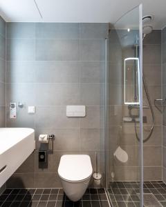 uma casa de banho com um WC e uma cabina de duche em vidro. em Thon Hotel Ålesund em Ålesund