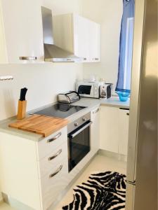 una pequeña cocina con armarios blancos y una alfombra de cebra en Guest House Jadro, en Rovinj
