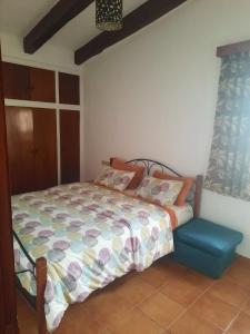 ein Schlafzimmer mit einem Bett und einem Stuhl darin in der Unterkunft Cosy Apartment à Kabila in Mʼdik