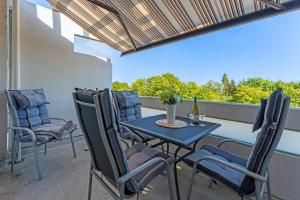 een patio met een tafel en stoelen op een balkon bij Driftberg 1 Haus A Wohnung 33 in Grömitz