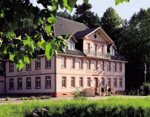 a large white building with a balcony on top of it at Landhaus Hechtsberg in Hausach