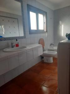 ein Badezimmer mit zwei Waschbecken, einer Badewanne und einem WC in der Unterkunft Cosy Apartment à Kabila in Mʼdik