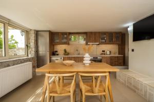 uma cozinha com uma mesa de madeira e cadeiras em Casa dei Sogni em Nerokoúros