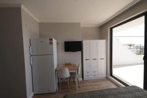 a kitchen with a refrigerator and a table and a window at Royal Homes 501 in Antalya